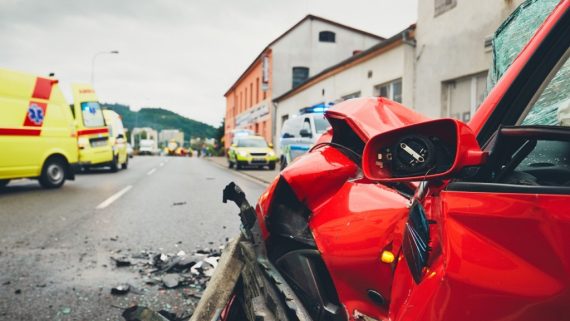 Close-up view at a crashed car. Teams of the Emergency medical service are responding to an traffic accident. - selective focus